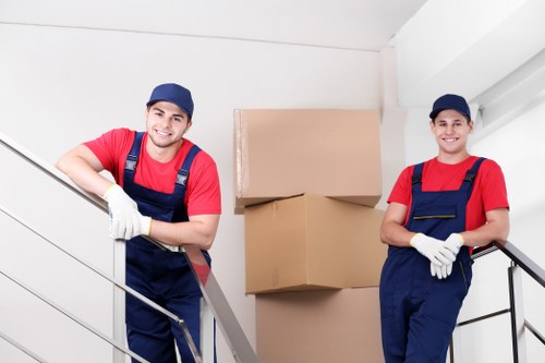 Professional movers carrying furniture through a flat building